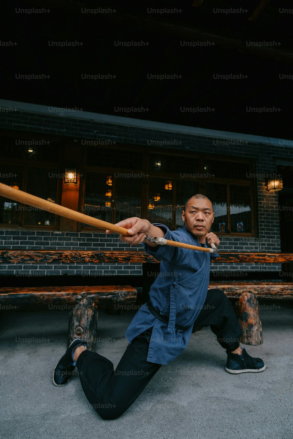 a man sitting on the ground holding a baseball bat