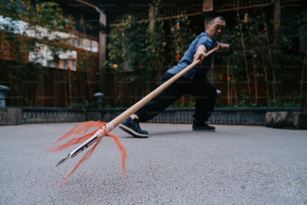 a man is throwing a broom on the street