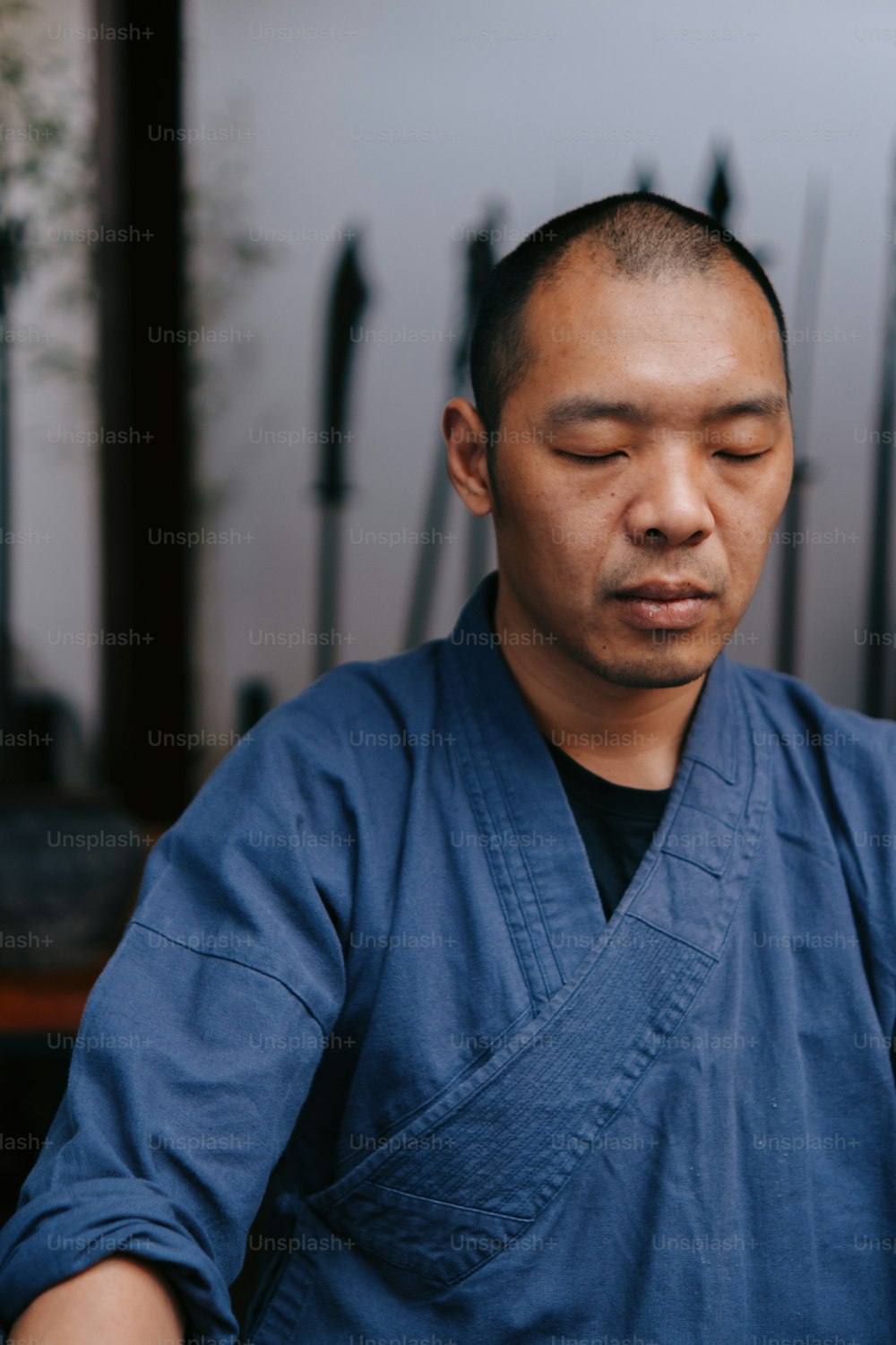 a man in a blue kimono holding a cell phone