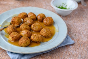 a white plate topped with meatballs covered in gravy
