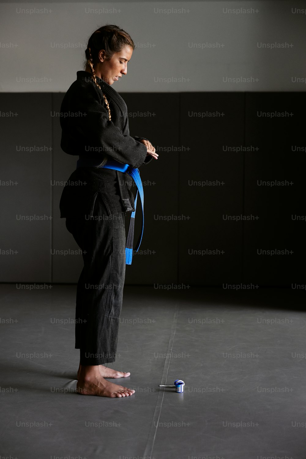 a woman in a black kimono is holding a blue belt
