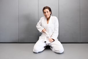 a woman sitting on the floor in a white outfit