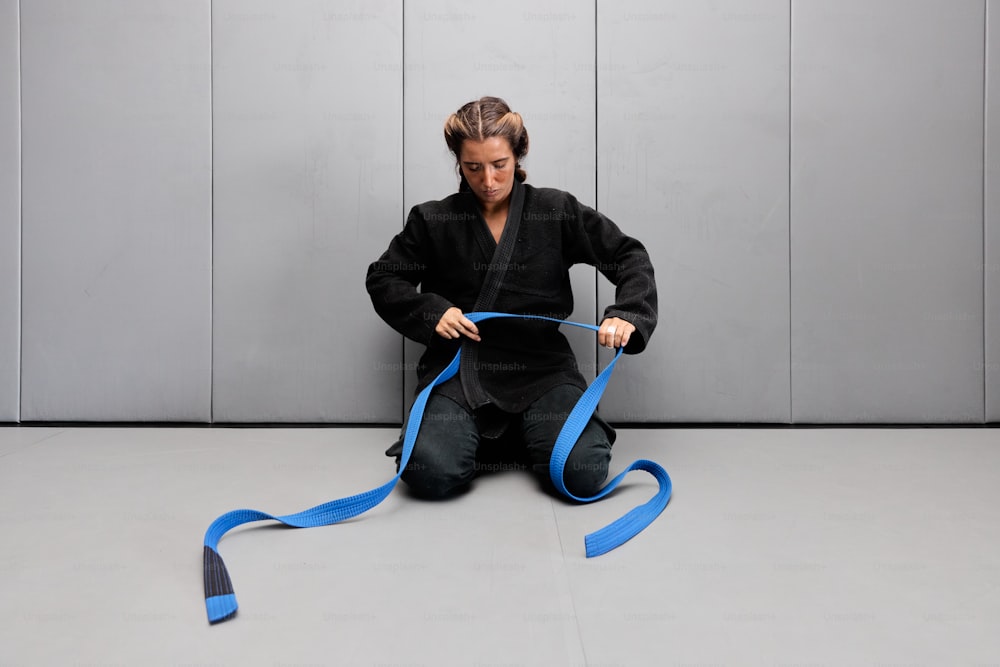 una mujer sentada en el suelo con una cinta azul
