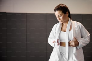 a woman in a white sports bra is holding a white towel