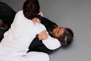 two women are fighting on a gray surface