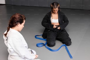 a woman sitting on the floor next to another woman