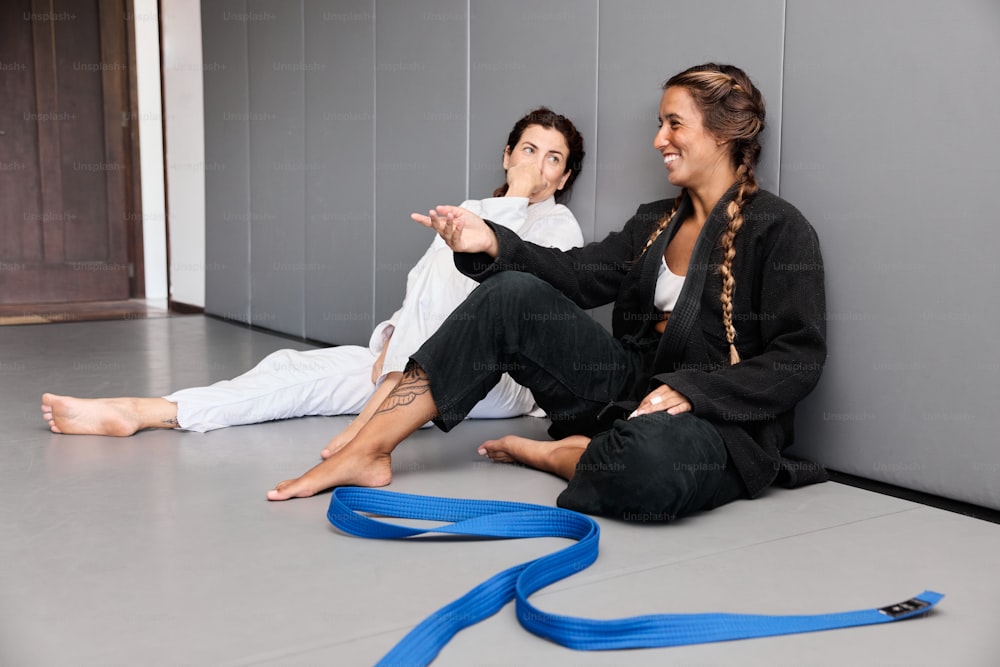 two women sitting on the floor with a blue leash