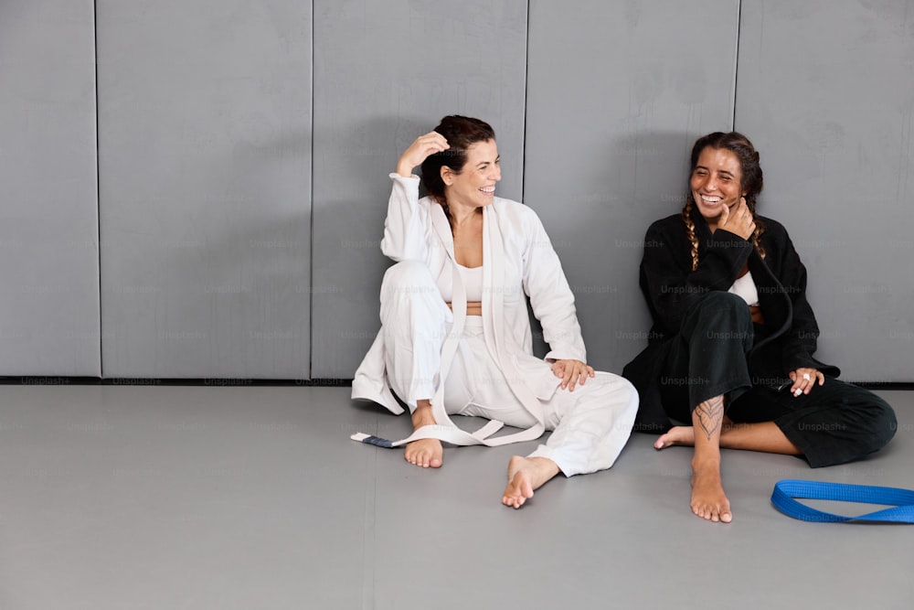 두 여자가 바닥에 앉아 웃고 있다