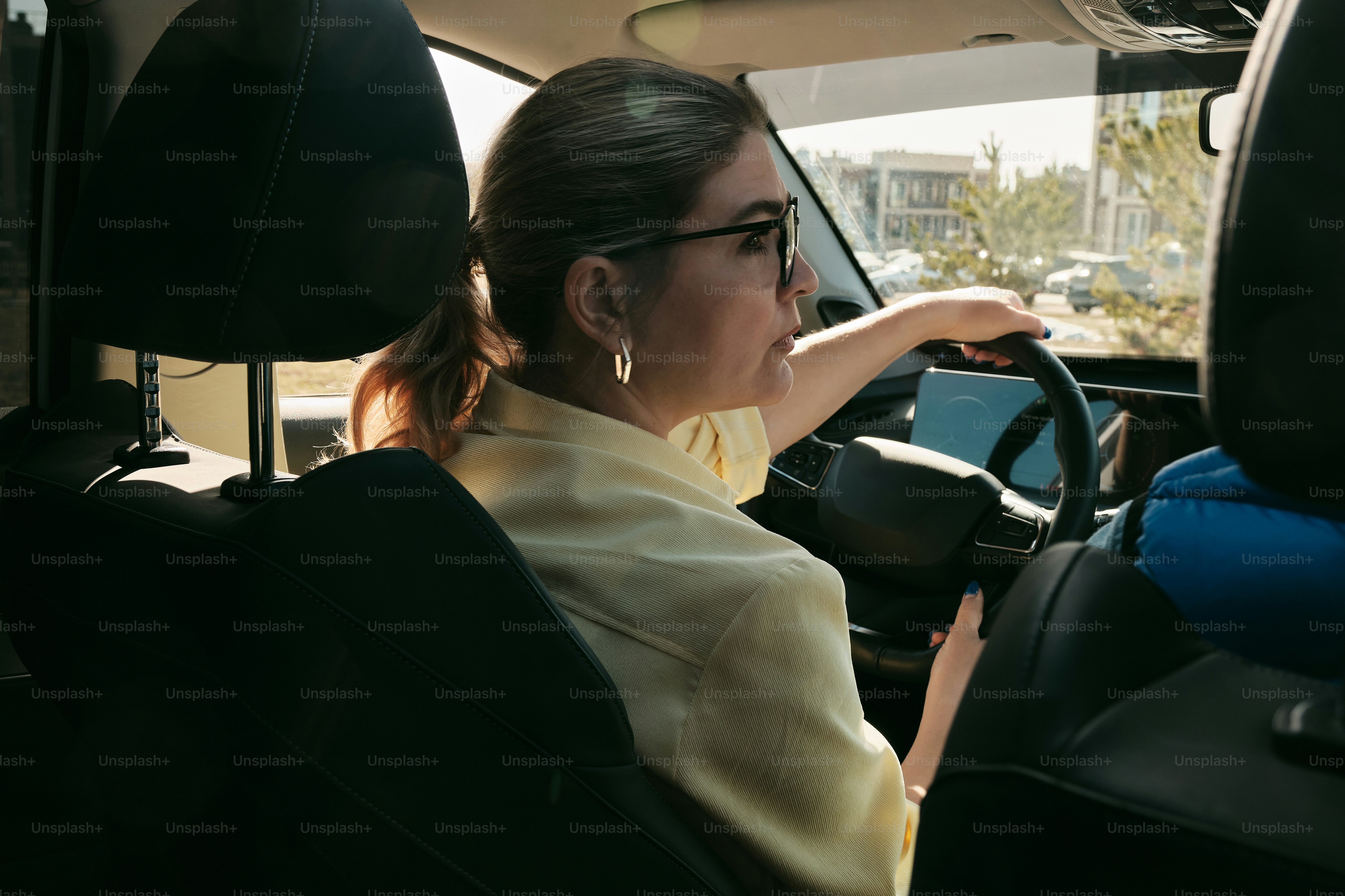 une femme conduisant une voiture avec un téléphone portable à la main