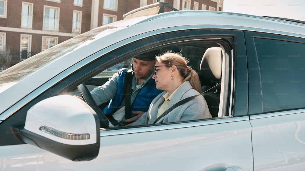un homme et une femme assis dans une voiture