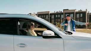 a man standing next to a woman in a car