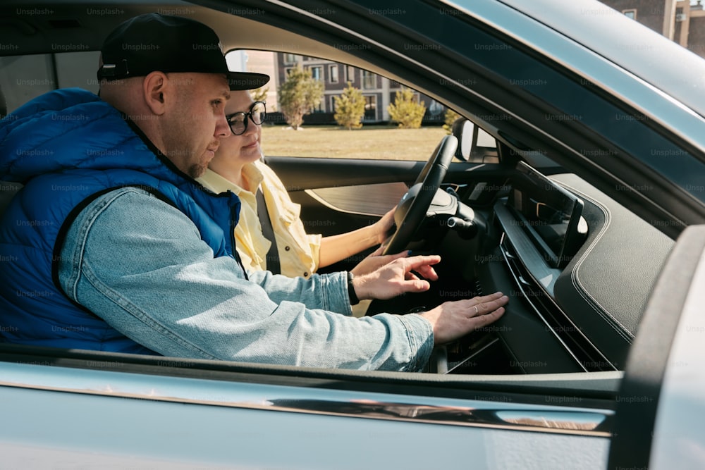 a man driving a car while wearing a blue vest