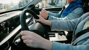 a man driving a car while holding a glass of wine