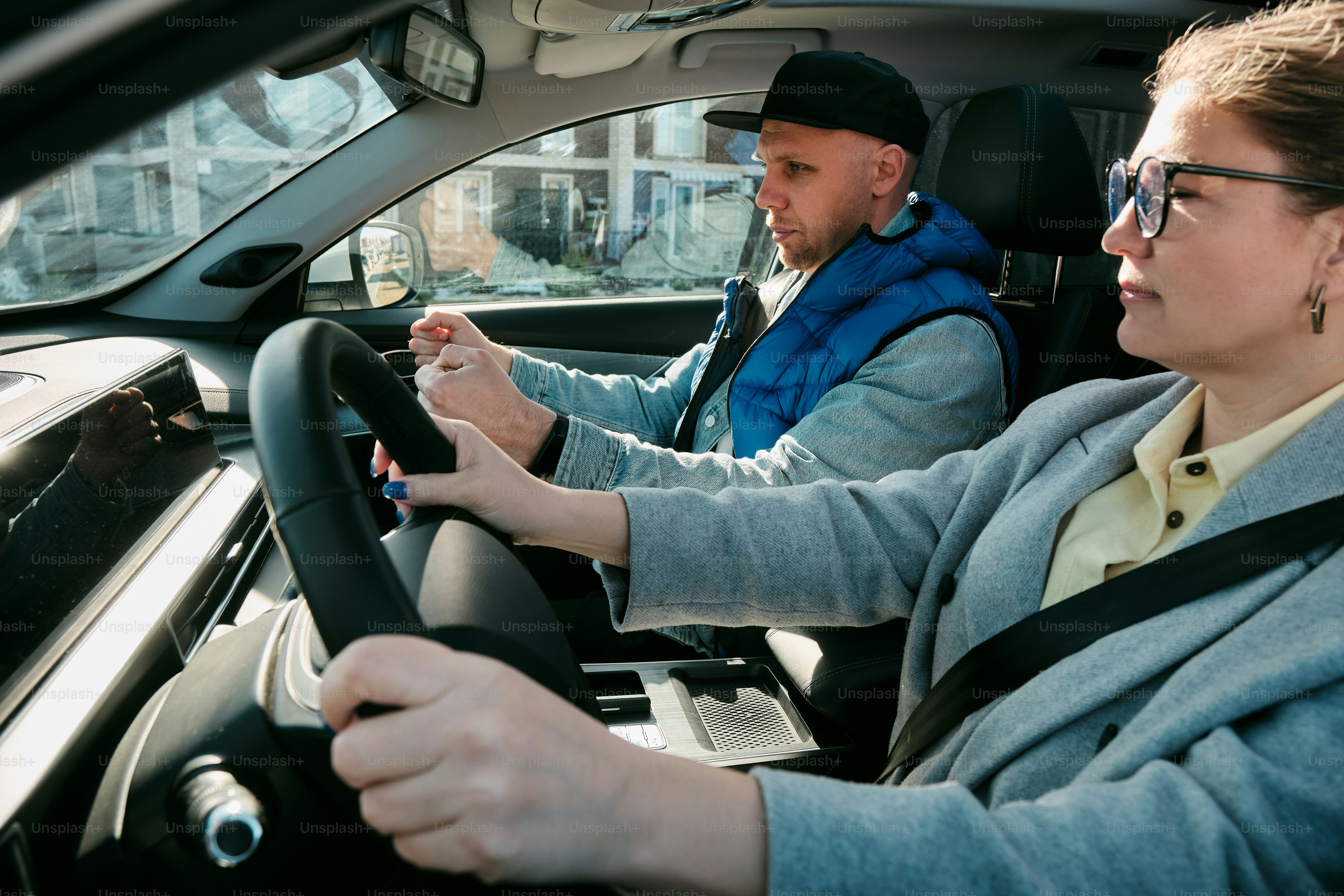 a man and a woman are driving a car