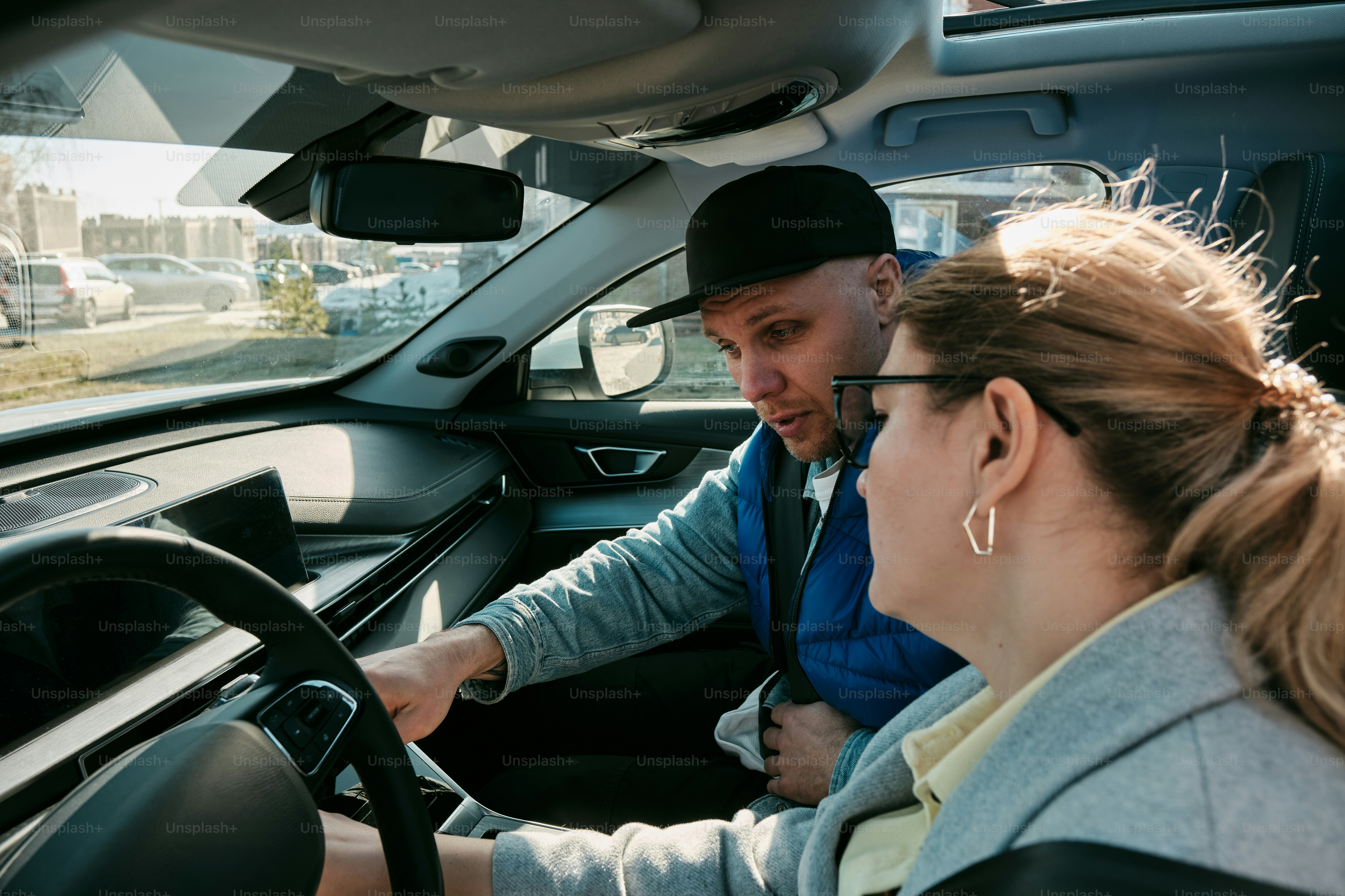 un homme conduisant une voiture avec une femme derrière lui