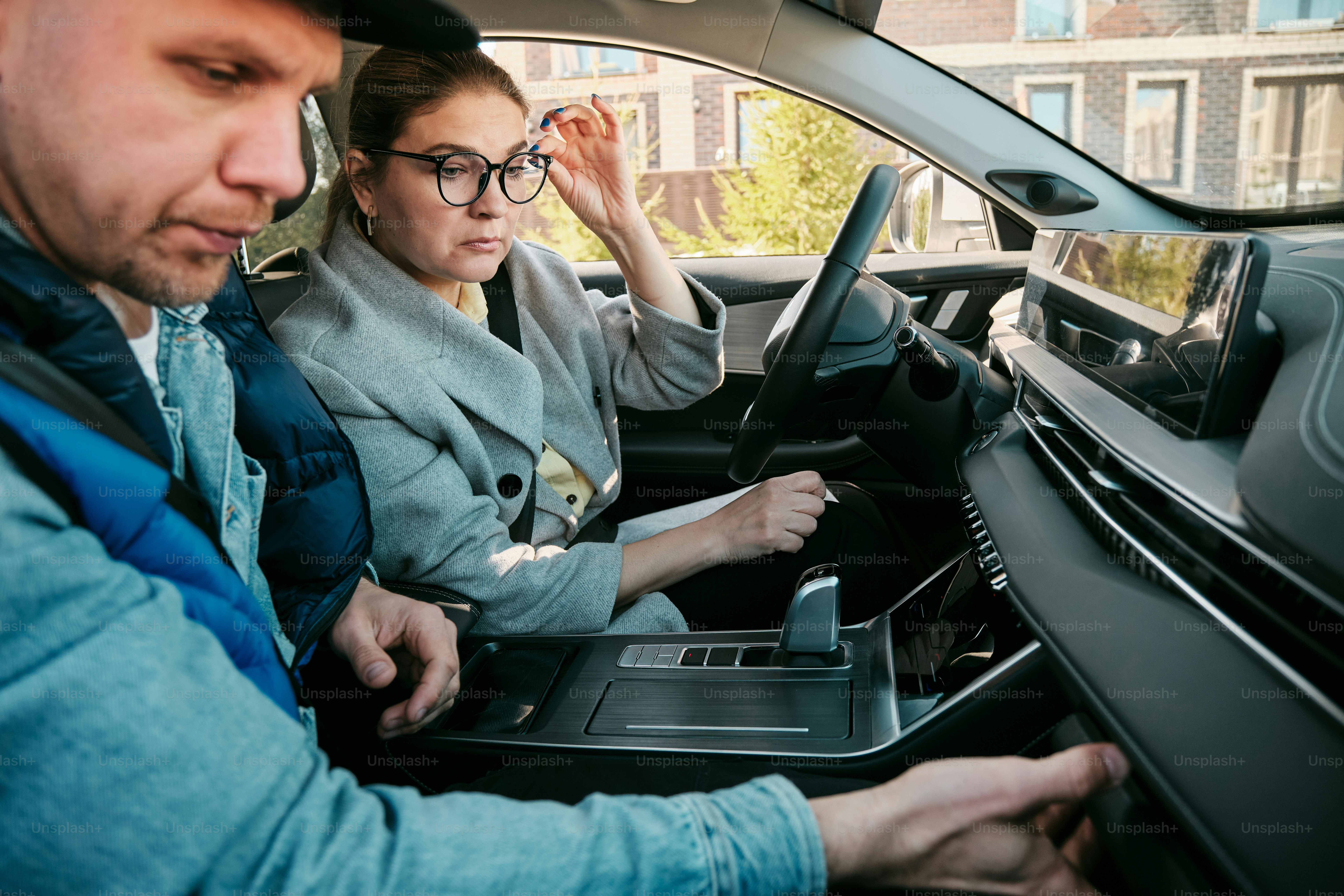 a man and a woman sitting in a car