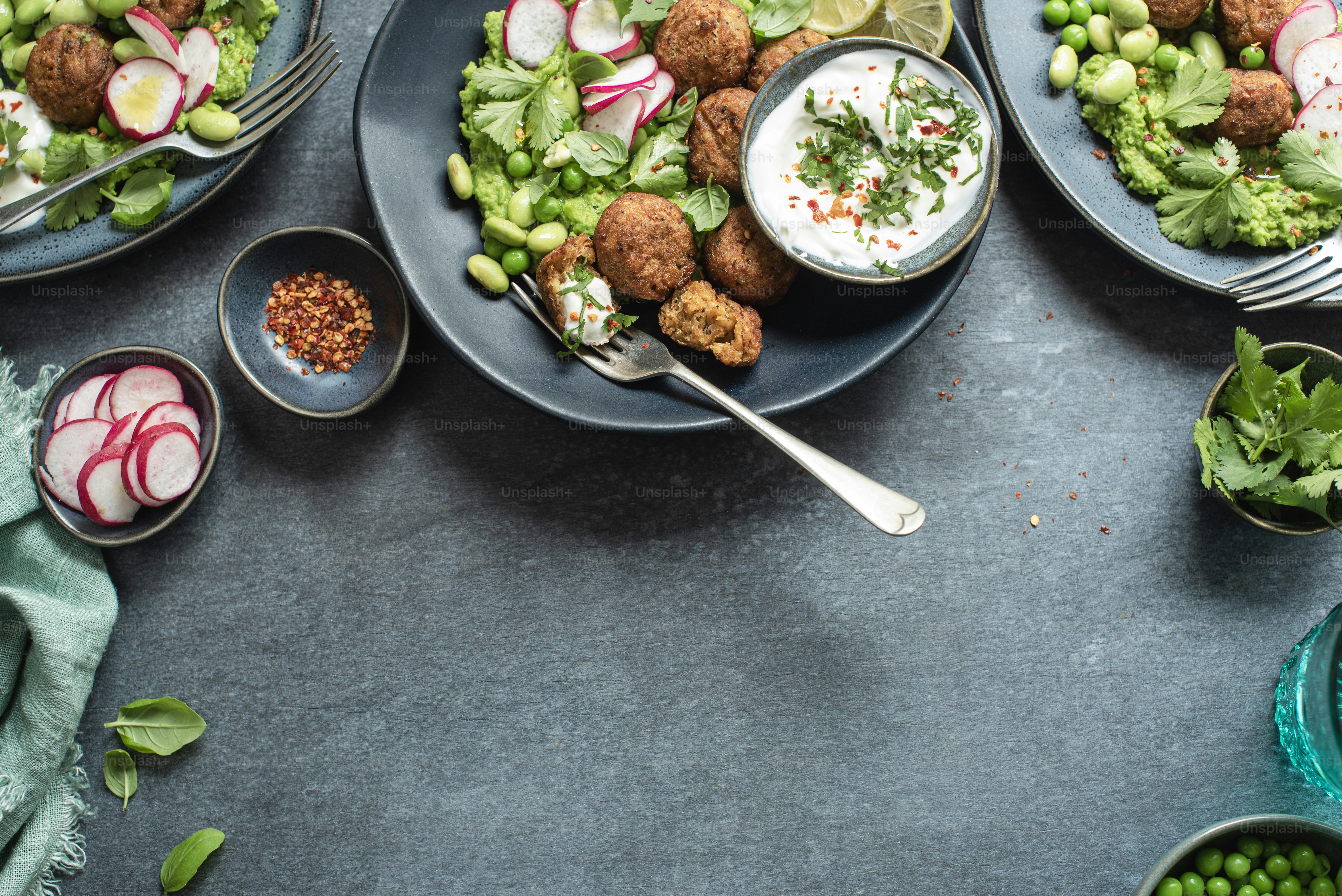 a table topped with plates of food and bowls of vegetables