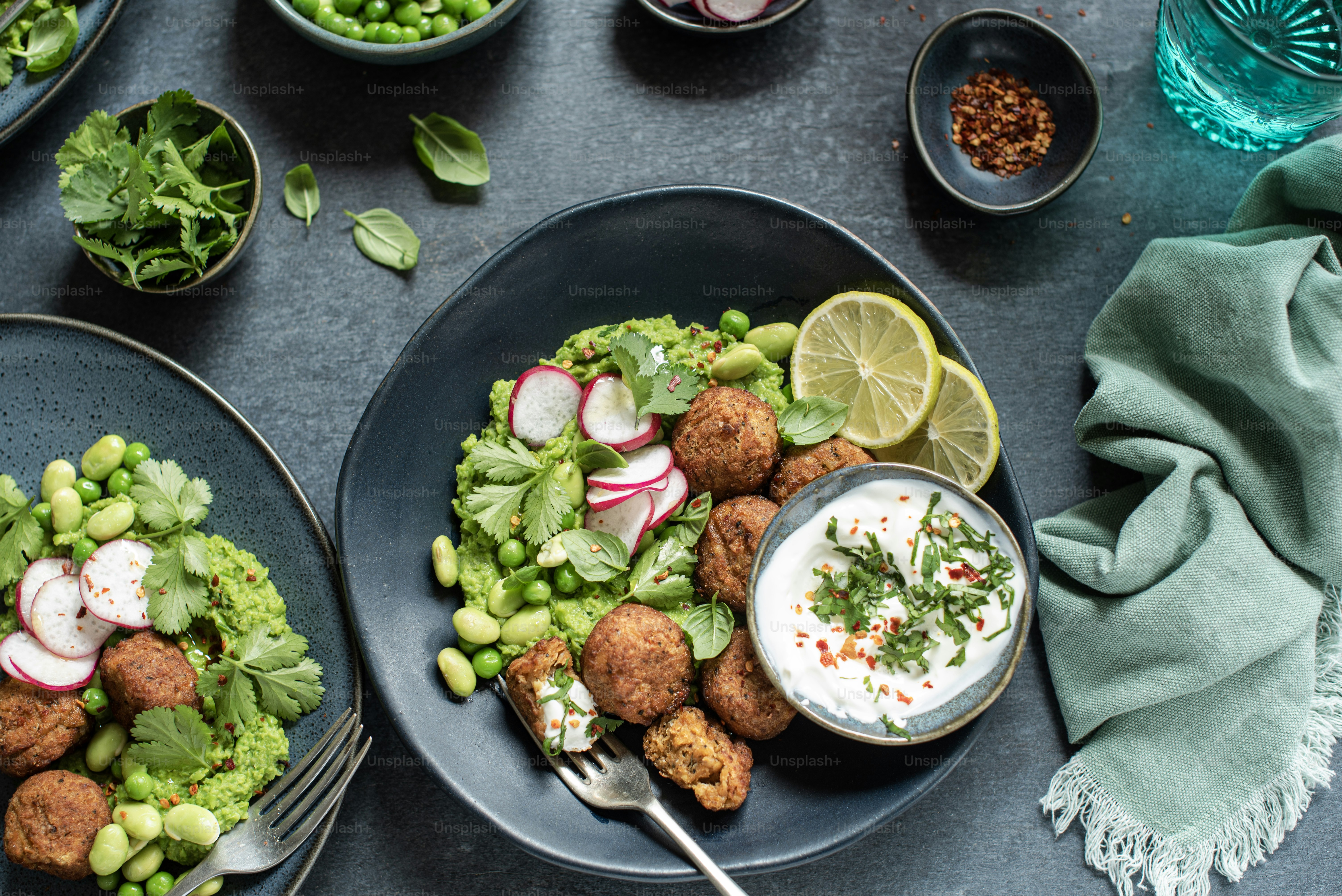 a table topped with plates of food and bowls of salad