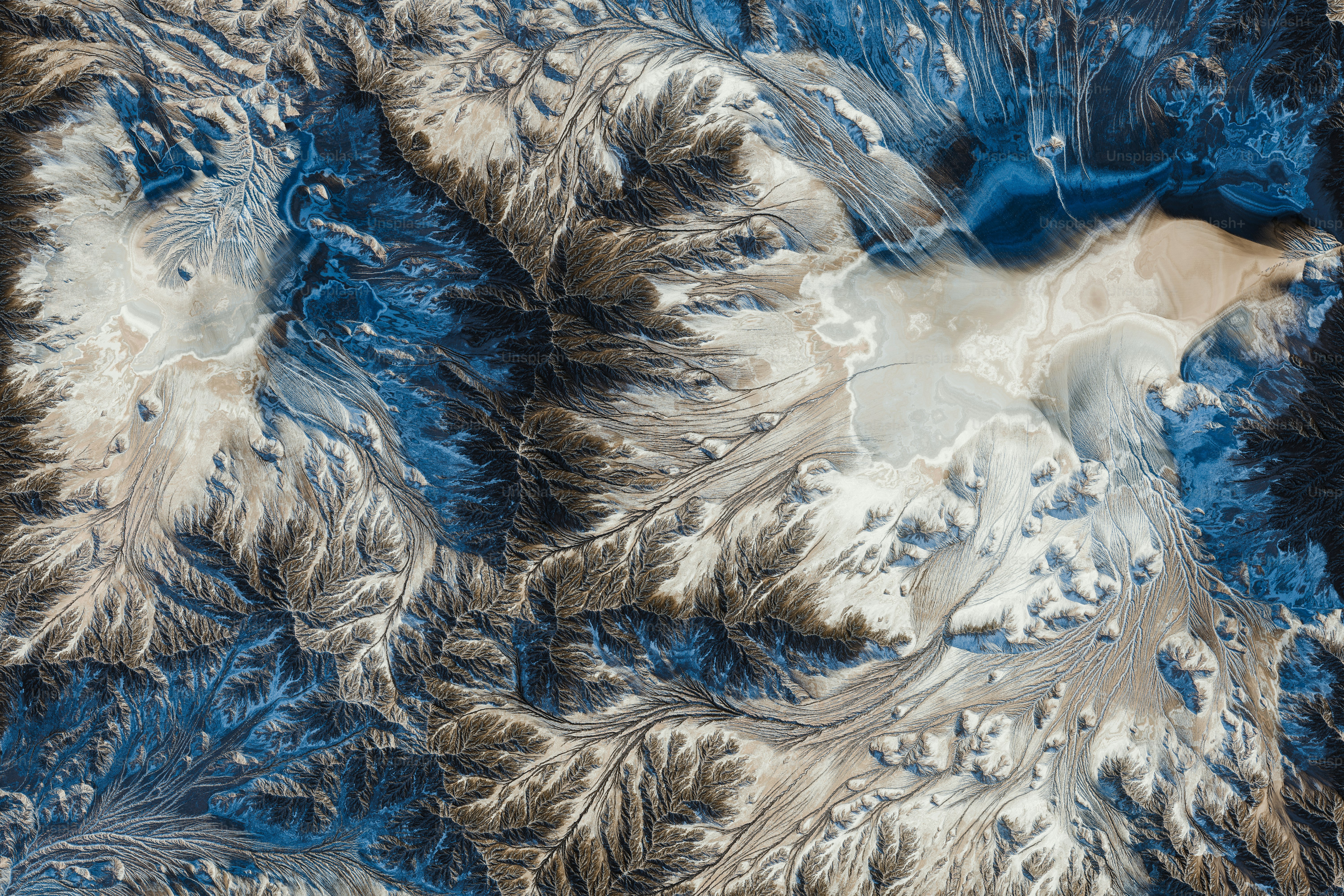 an aerial view of a snow covered mountain range