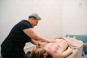 una mujer recibiendo un masaje en la espalda de una chica joven