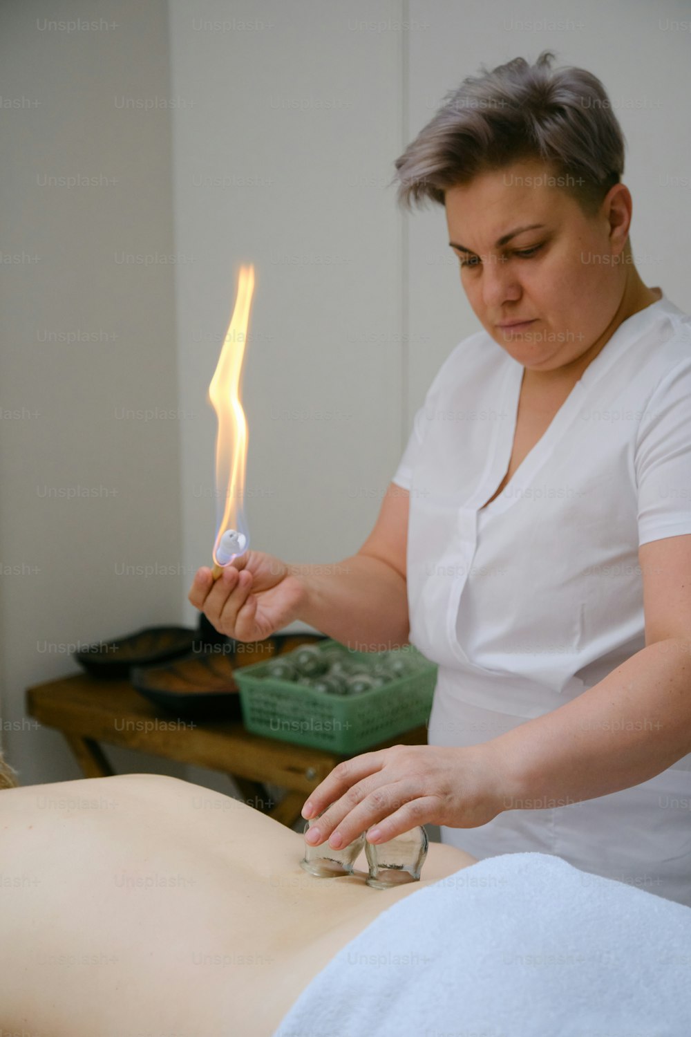 a woman getting a back massage with a lighter in her hand
