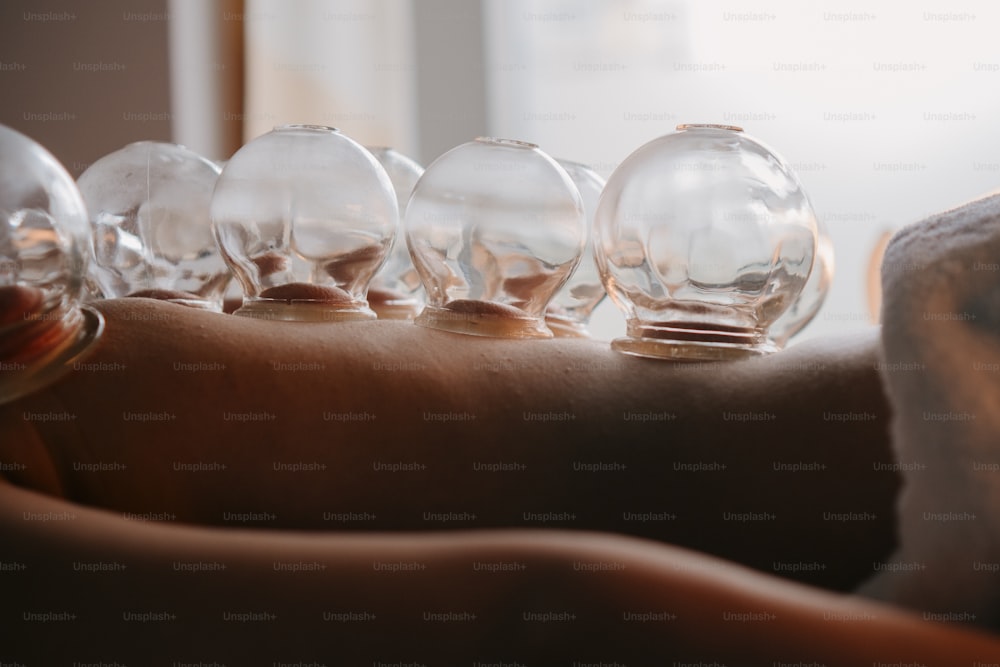 a row of glass globes sitting on top of a person's arm