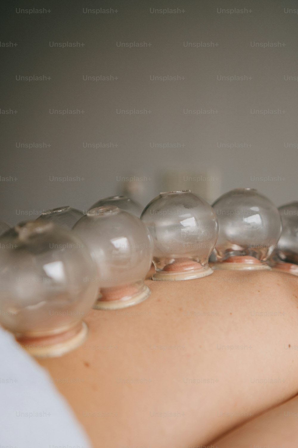 a woman laying down with a bunch of balls on her back