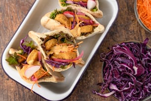 three fish tacos with coleslaw and carrot slaw