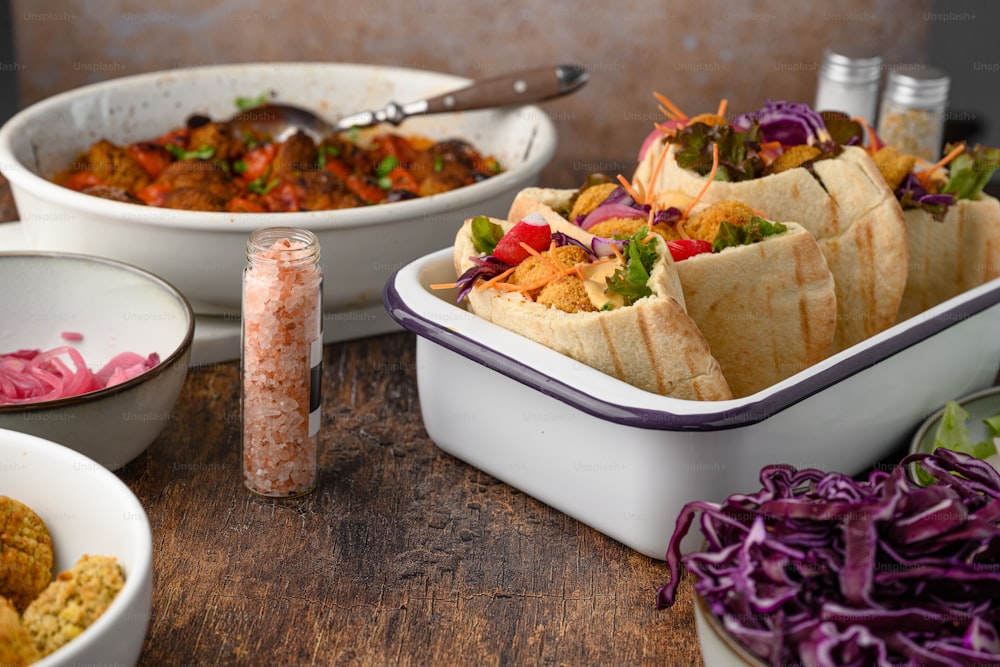 a wooden table topped with bowls of food