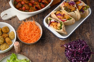 a wooden table topped with bowls of food