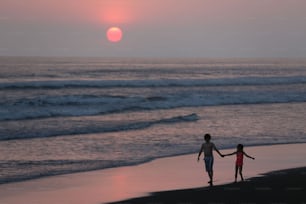 a couple of people that are walking on a beach