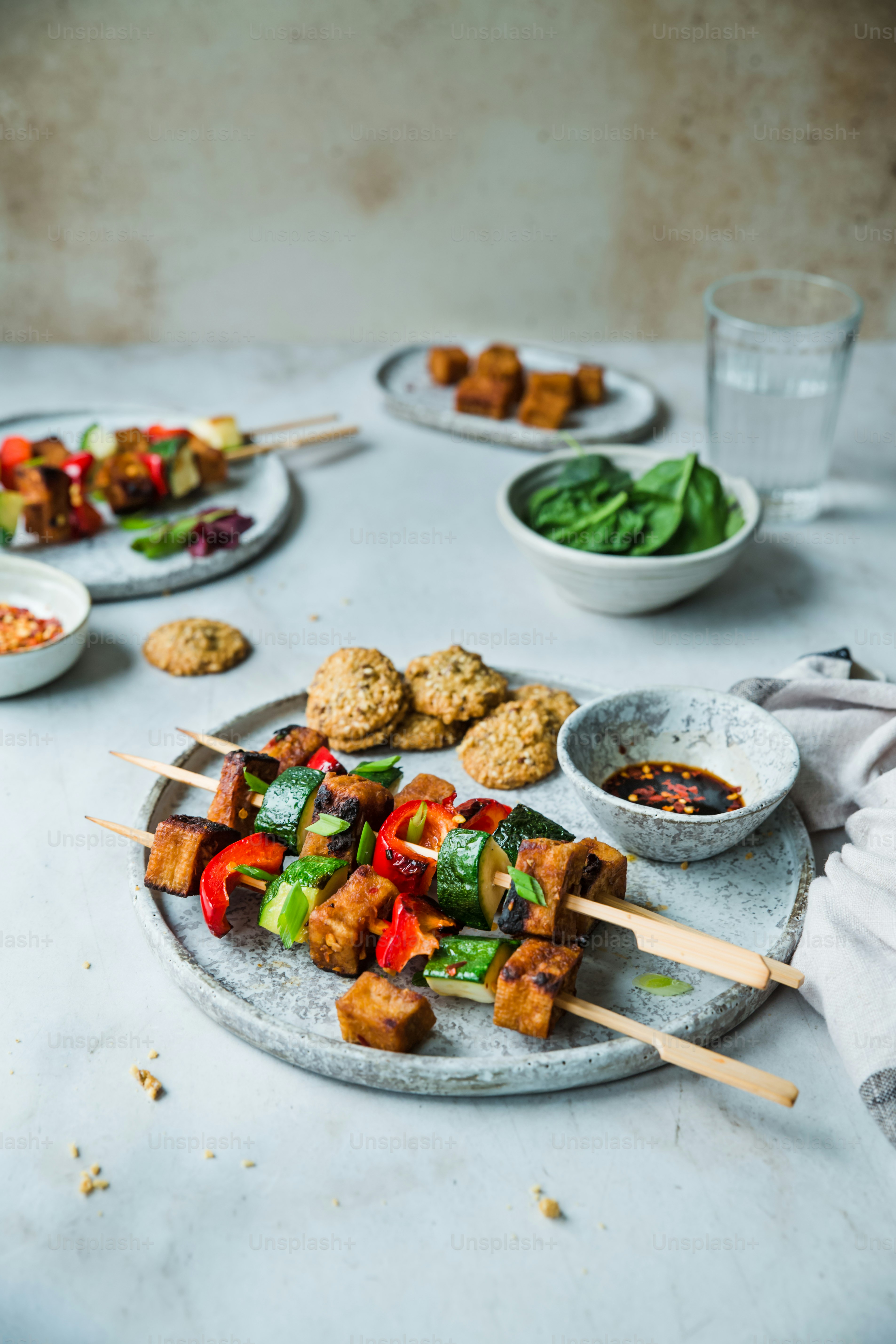 a table topped with plates of food and bowls of sauce