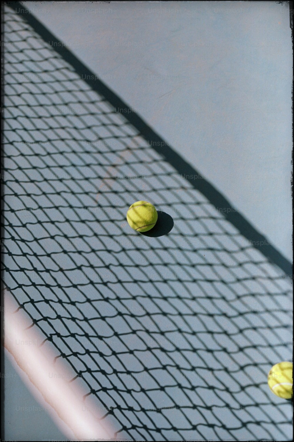 Tres pelotas de tenis en una red de cancha de tenis