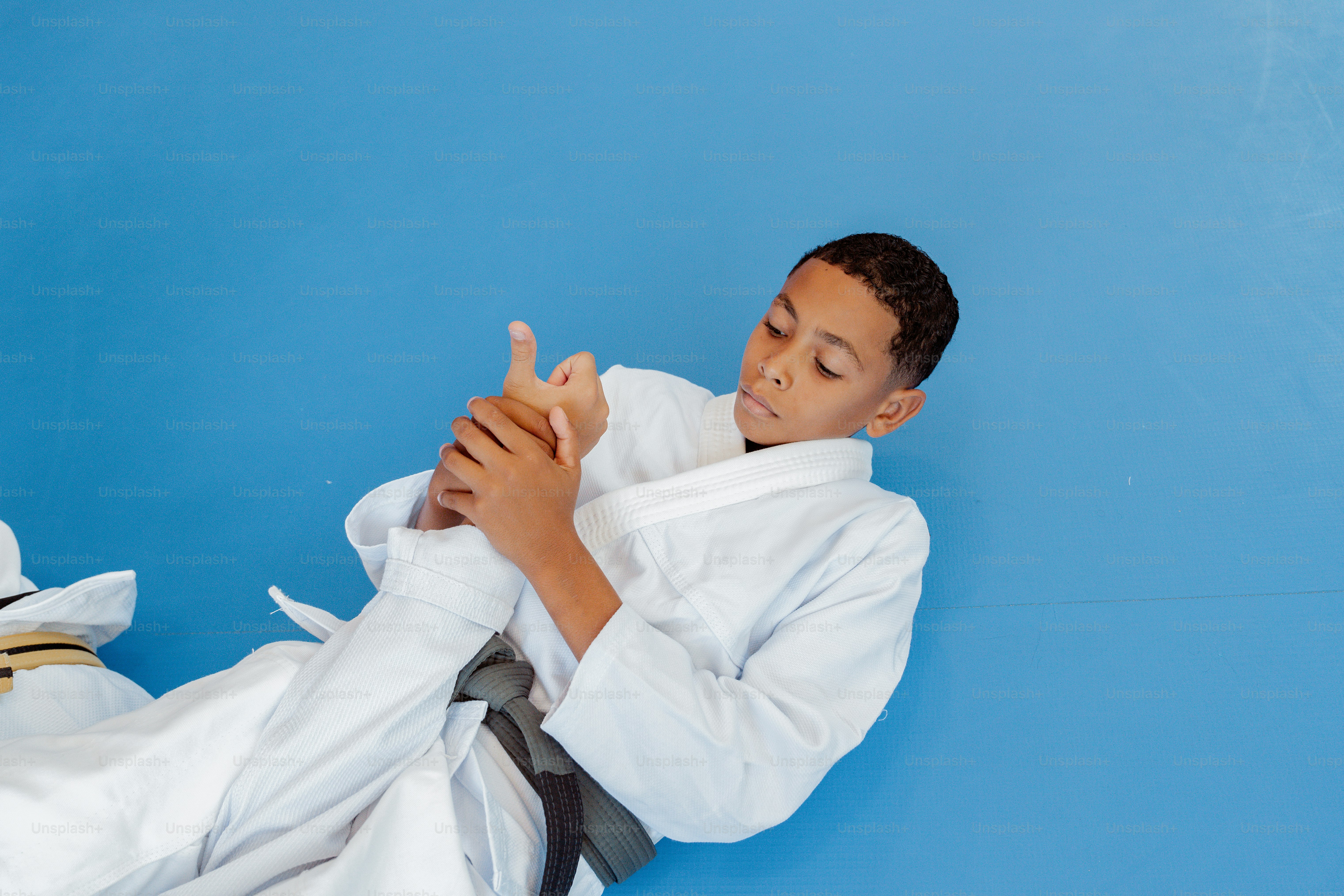 a boy in a white kimono is doing karate