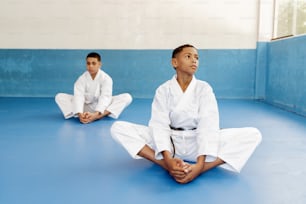 a couple of kids sitting on top of a blue floor
