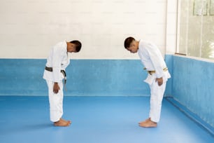 two young men standing in a room with blue flooring