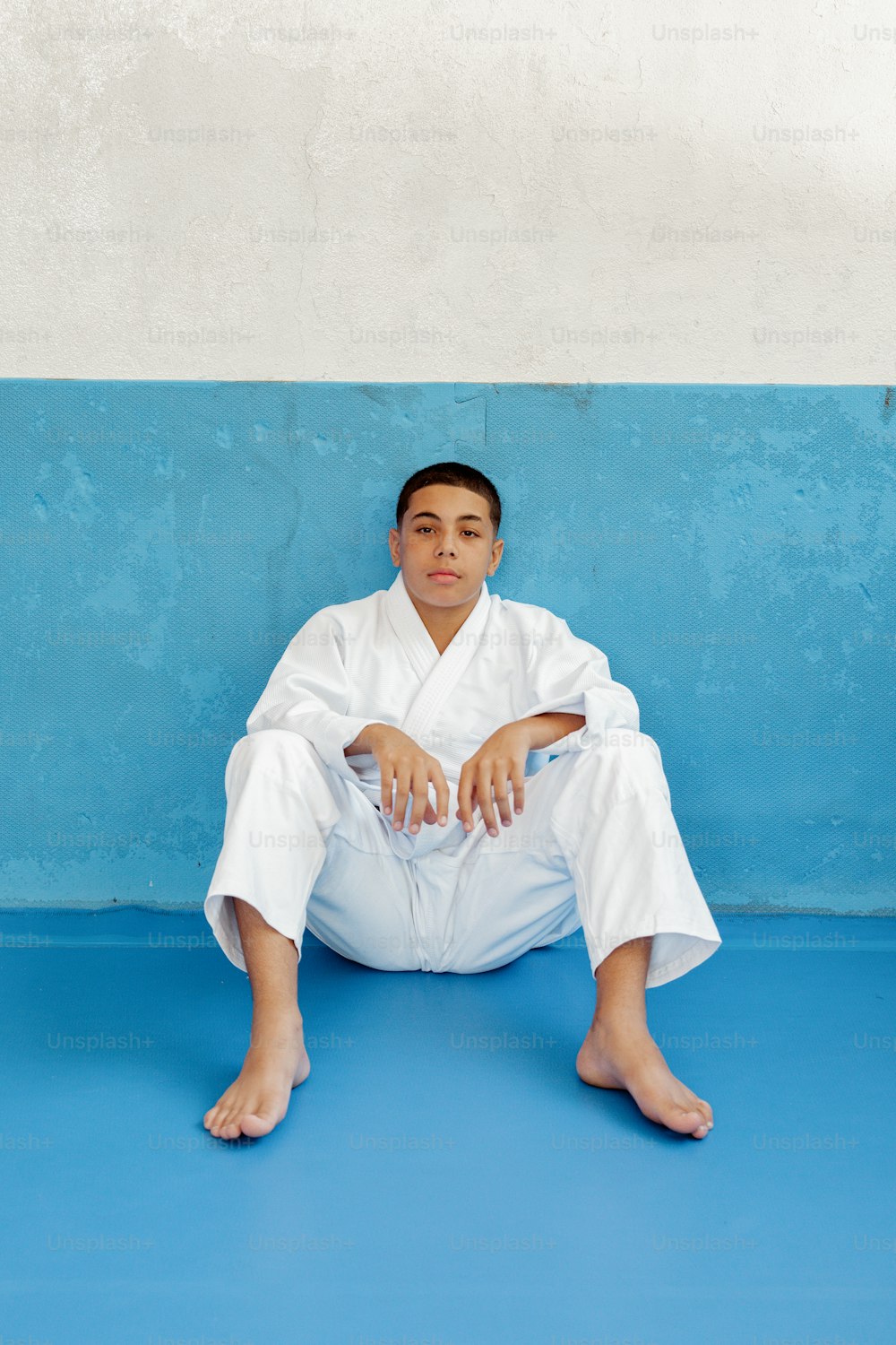 a man sitting on the ground in a white outfit
