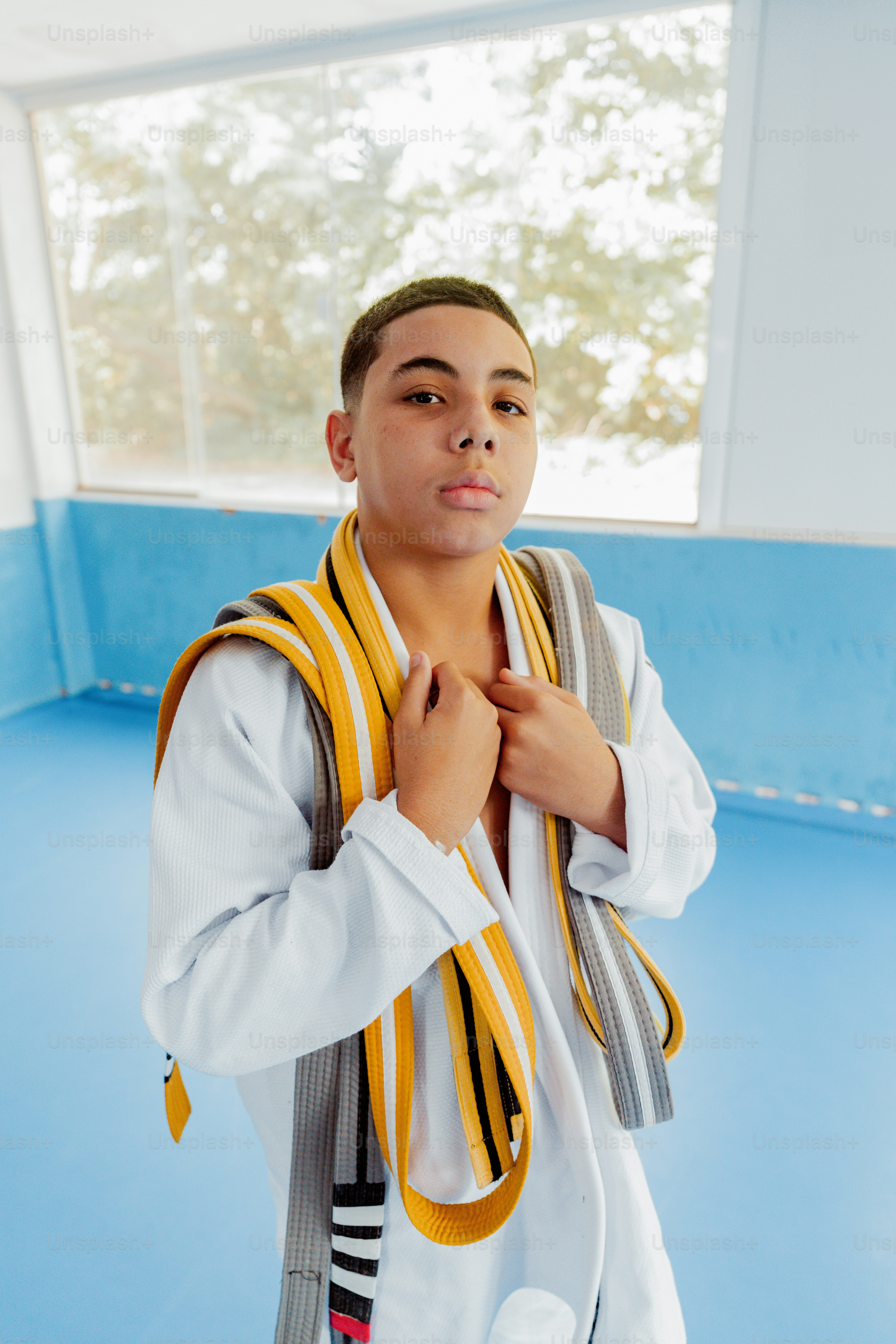a young man wearing a yellow and black striped scarf