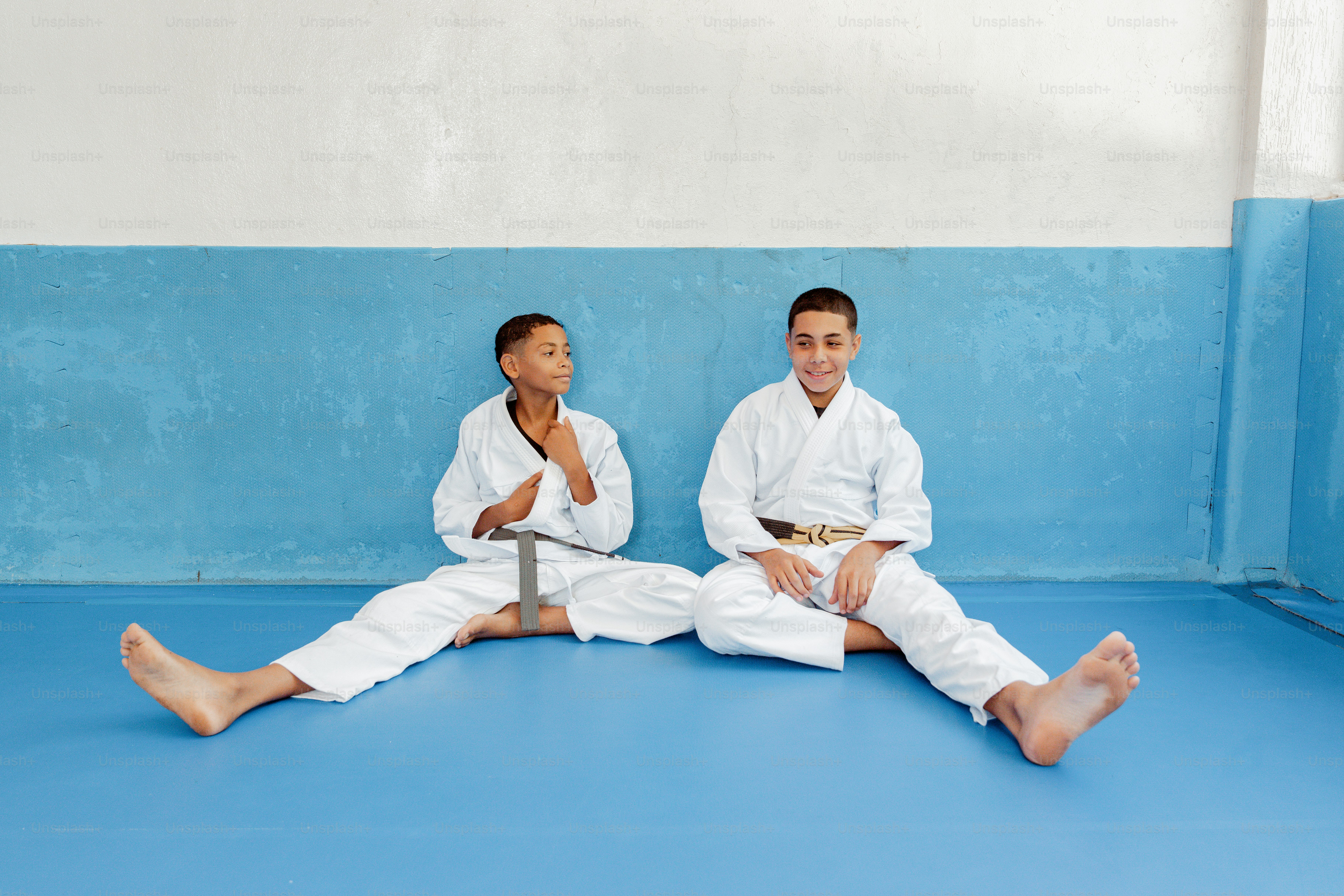 Two young men sitting on the ground in karate uniforms photo – Learning ...