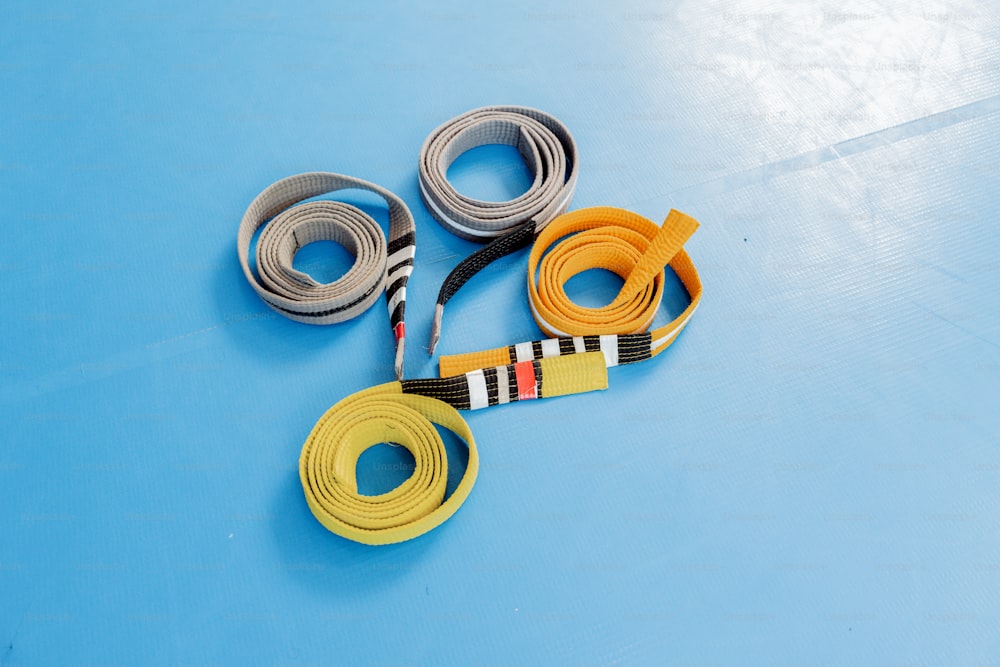 a pair of yellow, black, and white belts on a blue surface
