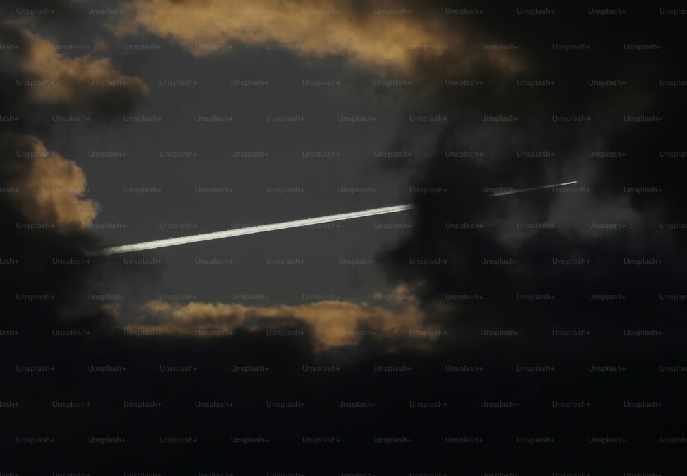 um avião está voando através do céu nublado