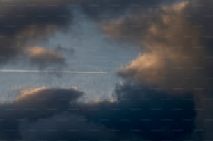 un aereo che vola attraverso un cielo blu nuvoloso