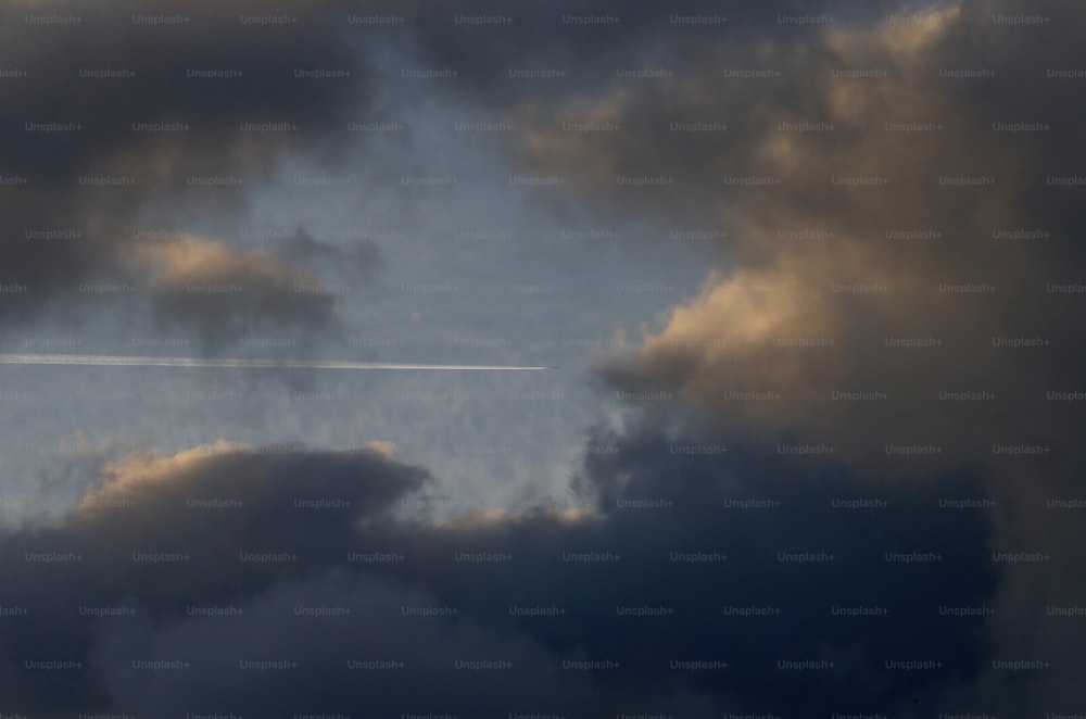 Ein Flugzeug, das durch einen wolkenverhangenen blauen Himmel fliegt
