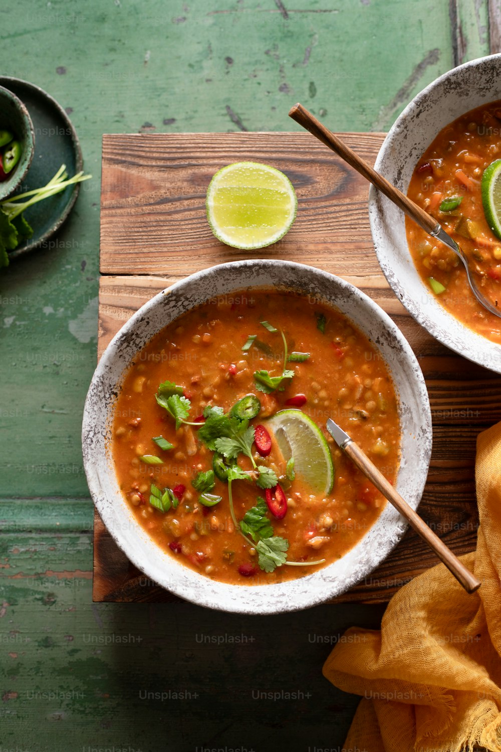 two bowls of chili soup with limes and cilantro