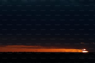 Il sole sta tramontando sull'oceano con nuvole scure