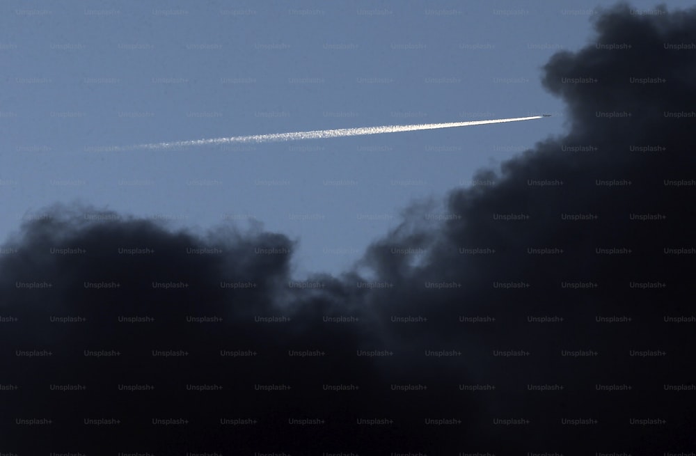 un jet volant dans un ciel bleu avec des nuages