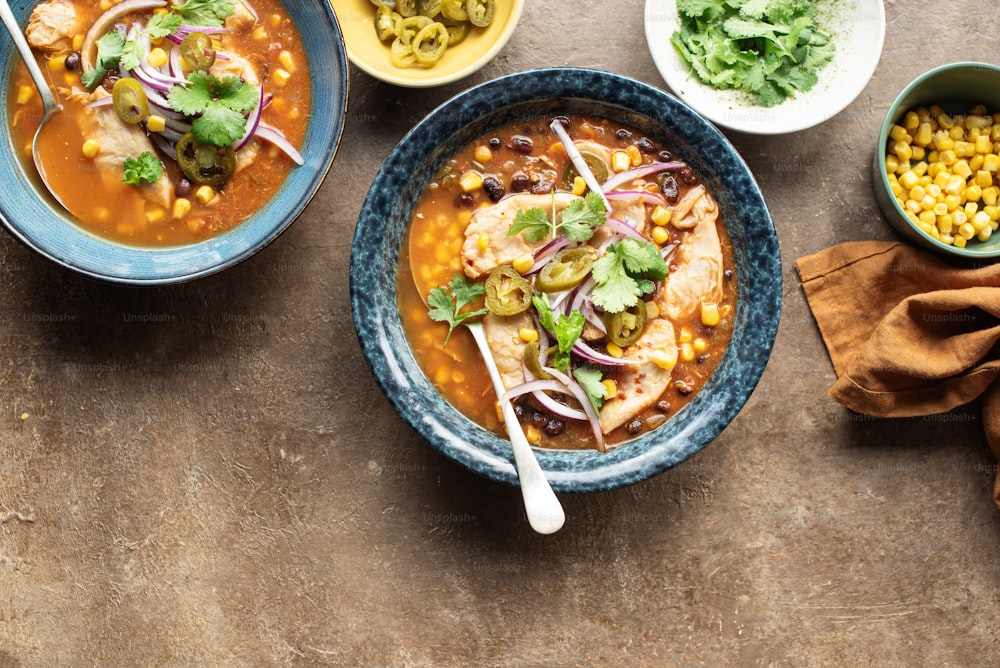 una mesa cubierta con cuencos de sopa y cuencos de verduras