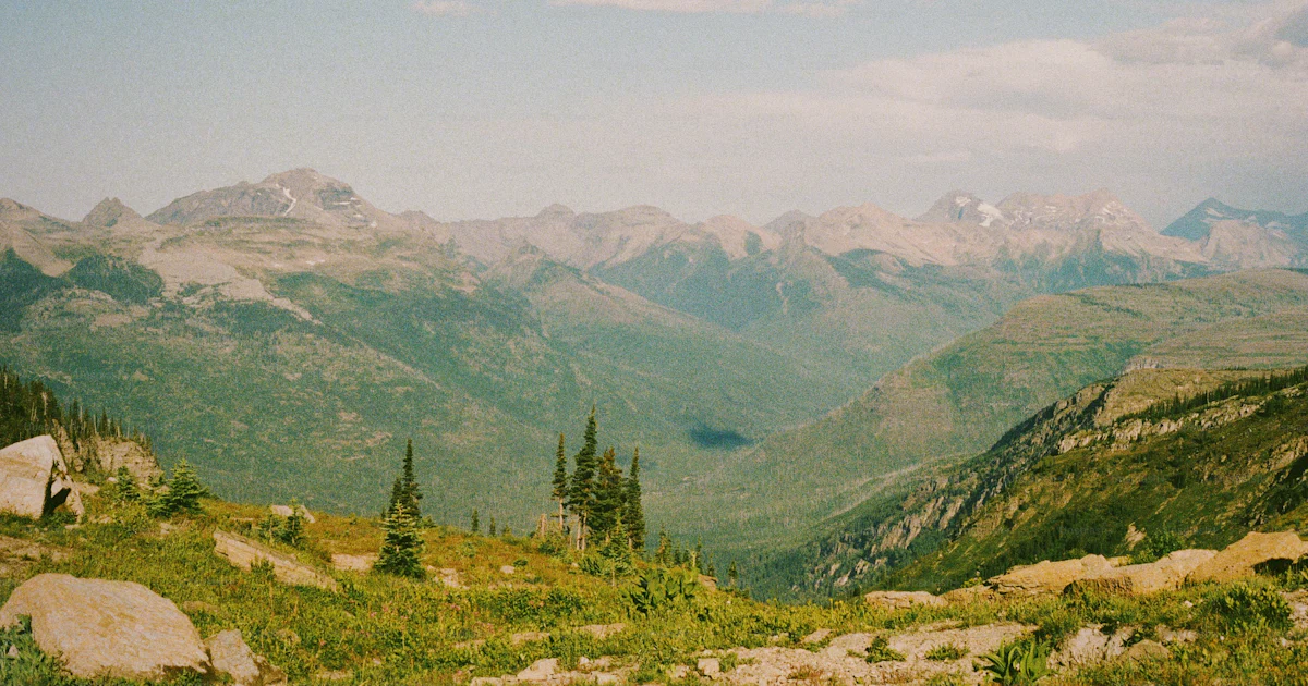 A scenic view of a mountain range with trees and mountains in the ...