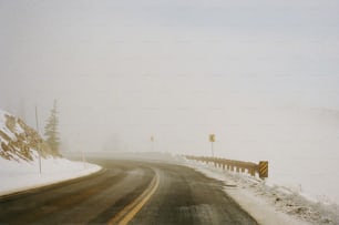 a snow covered road with a yellow sign on it