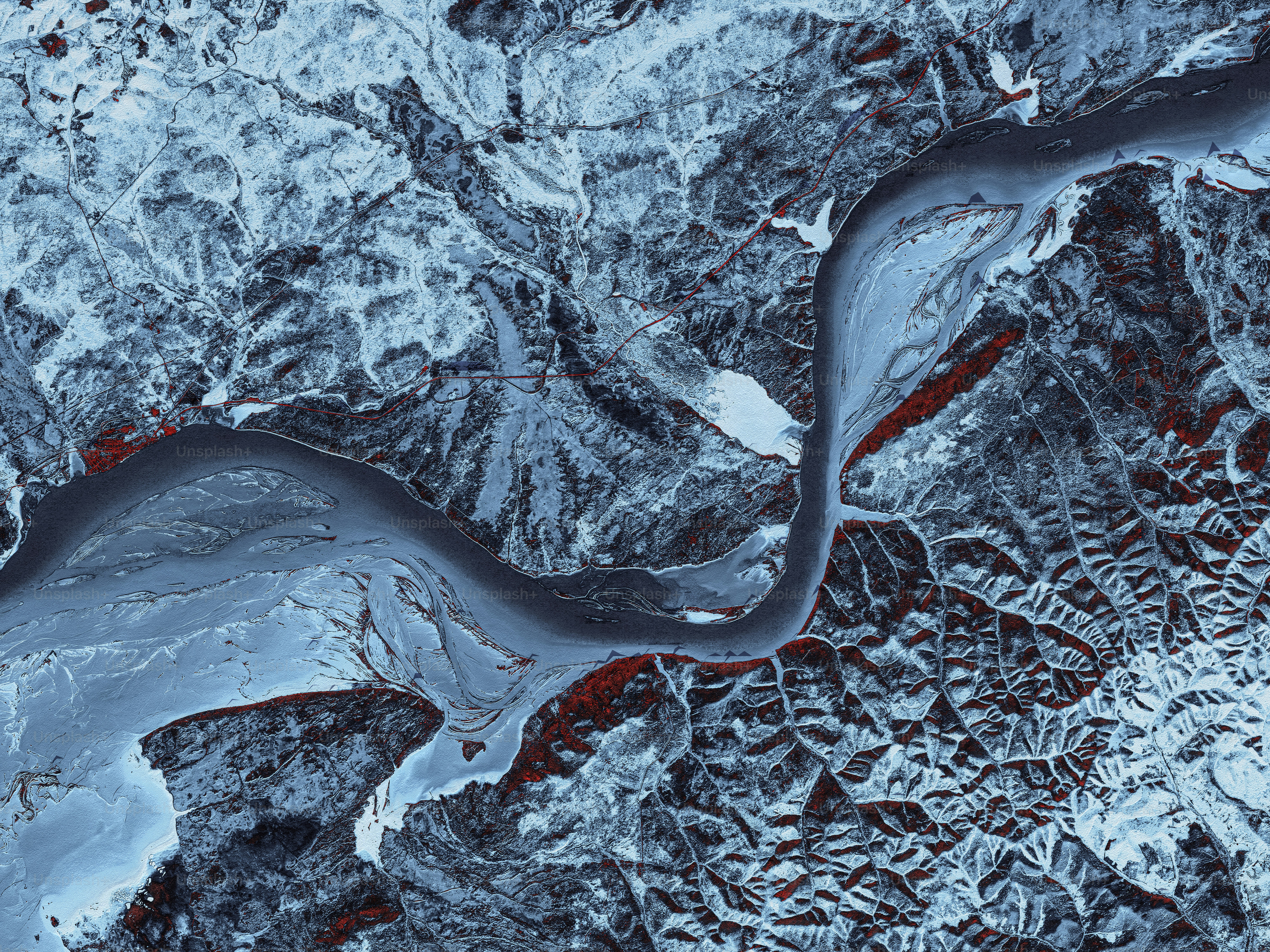 an aerial view of a river in the snow